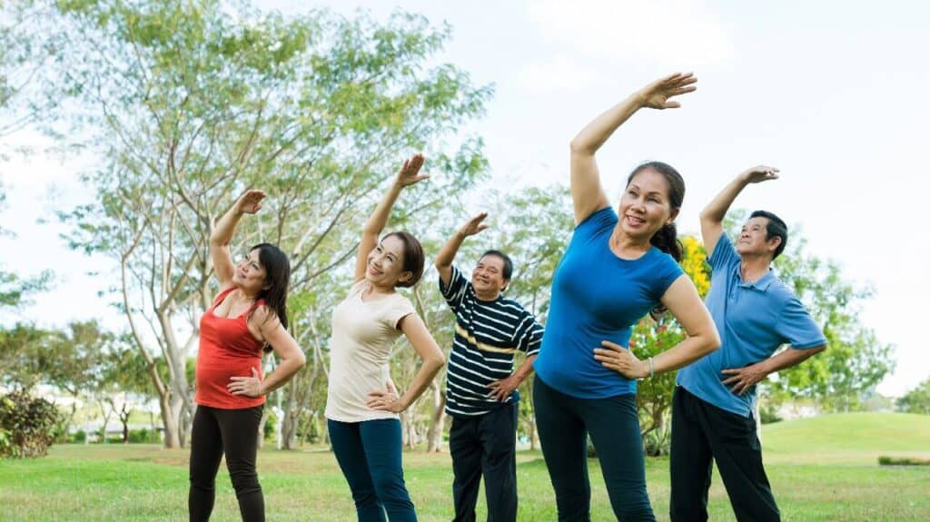Chân dung người cao tuổi tập yoga chống đau nhức xương khớp ngoài trời.